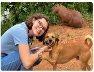 Cachorro caramelo sorri e faz pose em foto com universitária e capivara